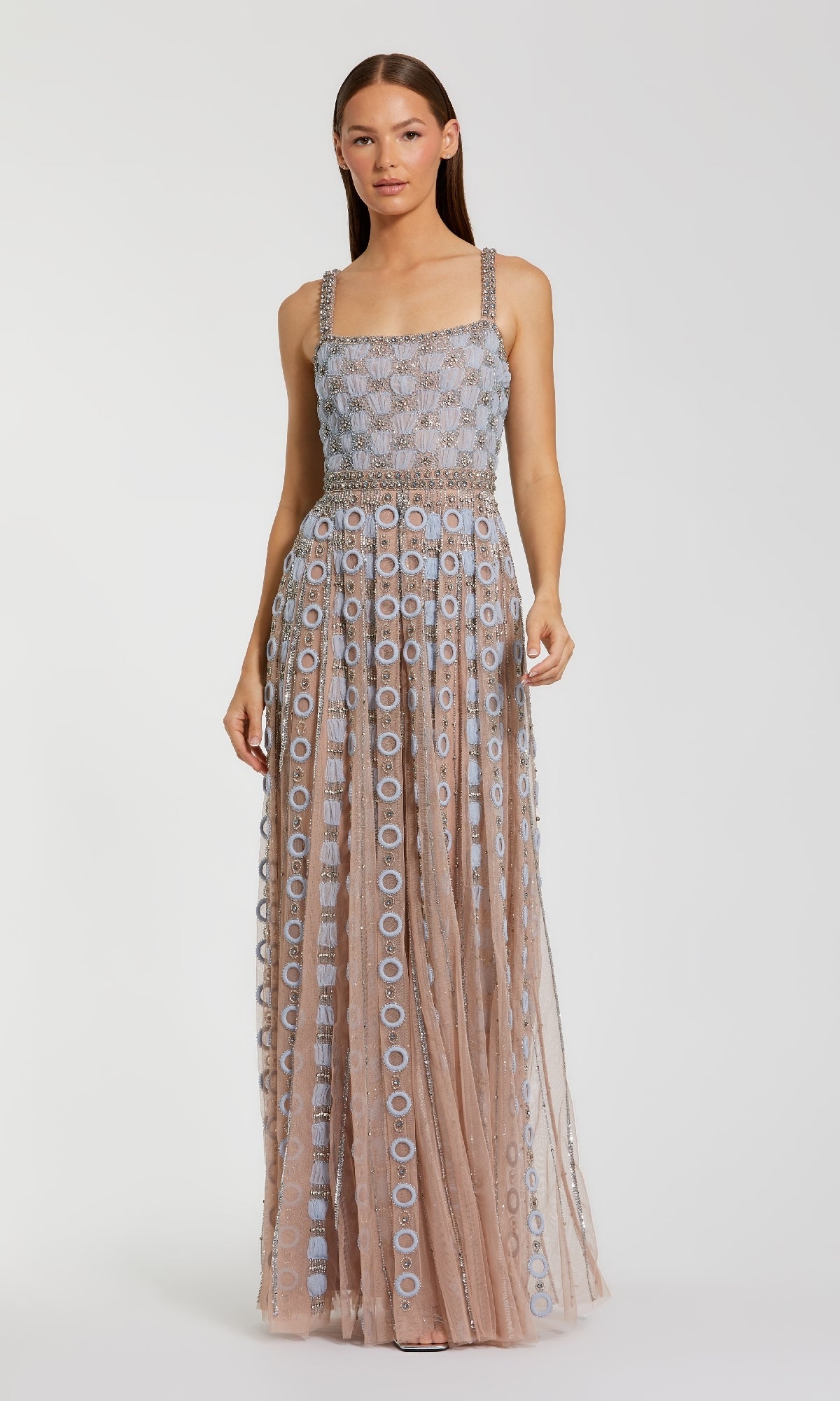 A woman wearing the Embellished A-Line Formal Dress: Mac Duggal 10106, a sleeveless, floor-length gown with a square neckline and geometric circular patterns in light blue and nude.
